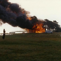 Рекламный материал. Г.Гисладоттир возле горящего дома